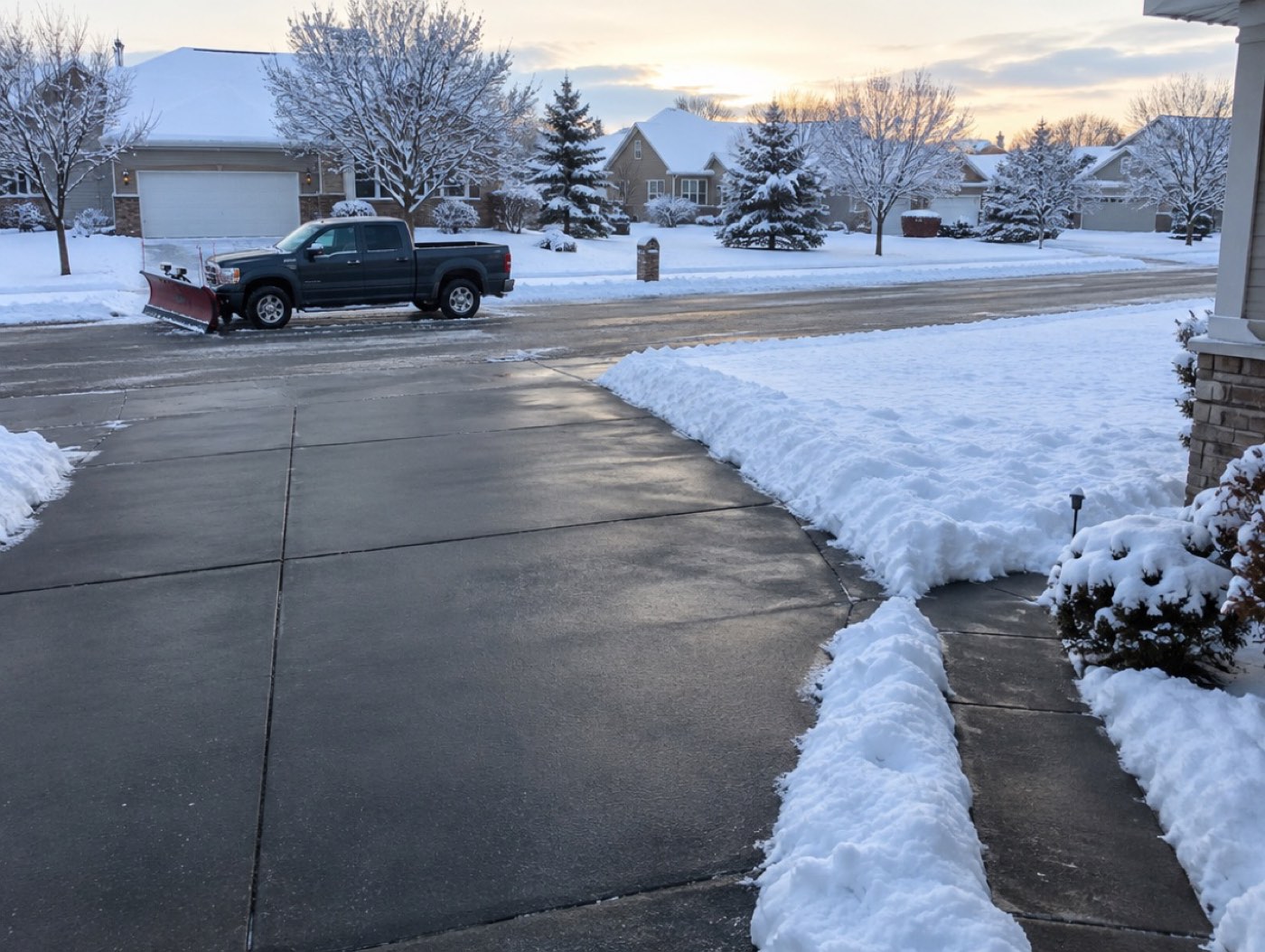 Illustration: a driveway cleared of snow with a plow truck at the curb