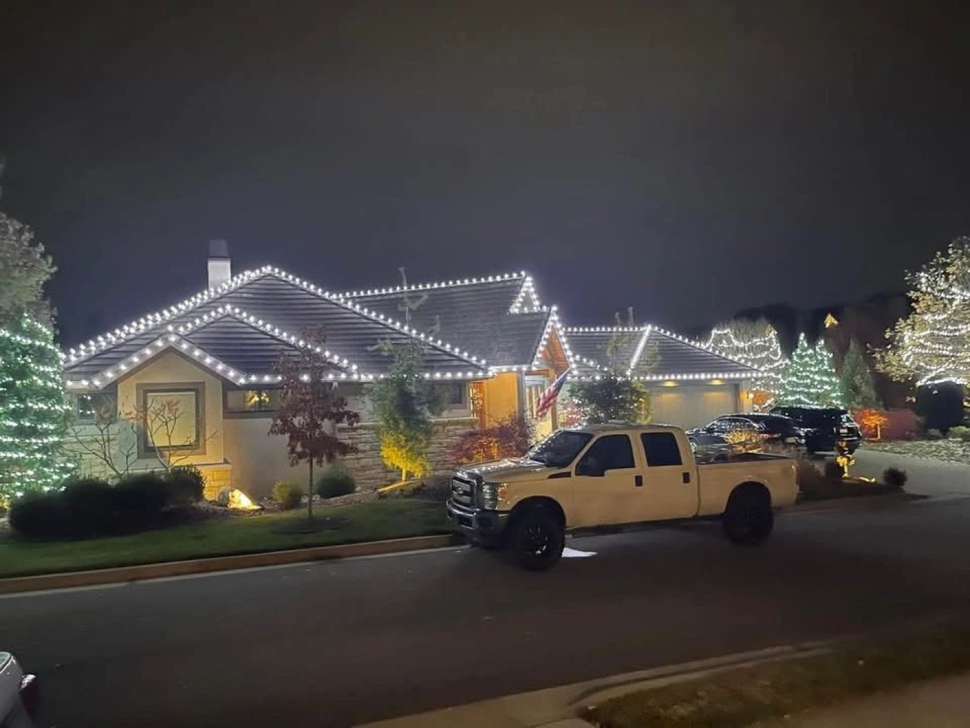 Ranch home with roofline and evergreen tree lights