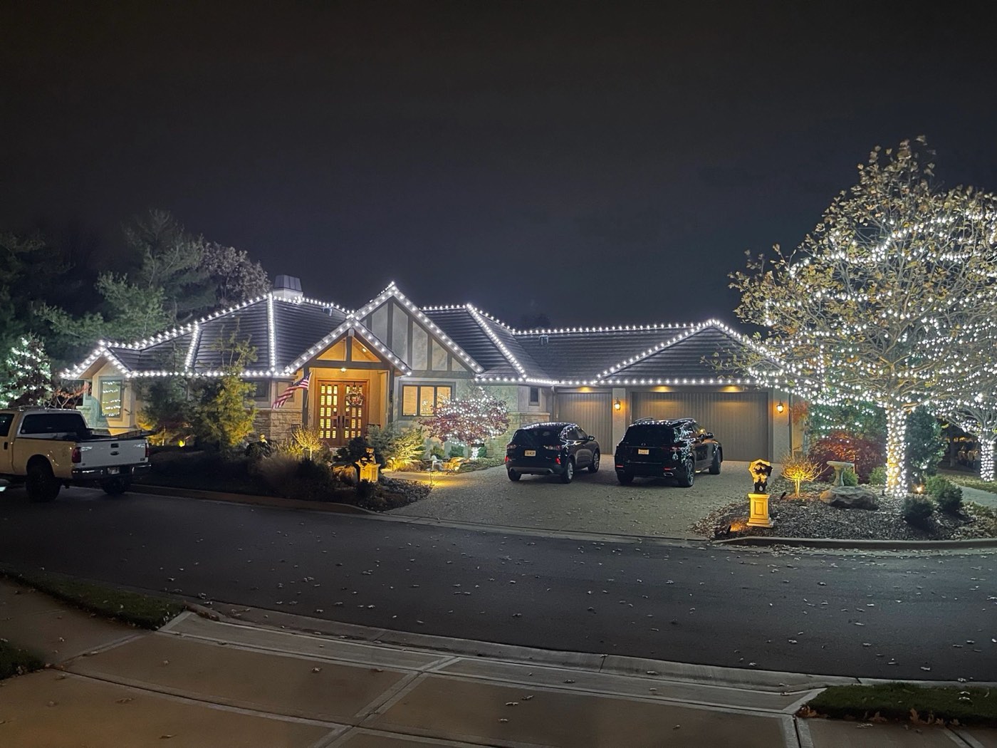 Ranch home and trees wrapped in holiday lights