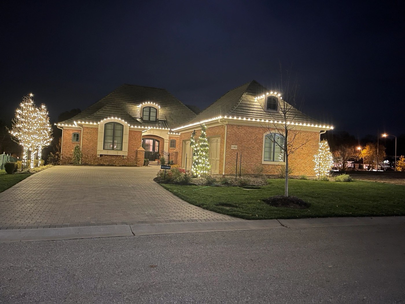 Brick home with roofline and tree lights